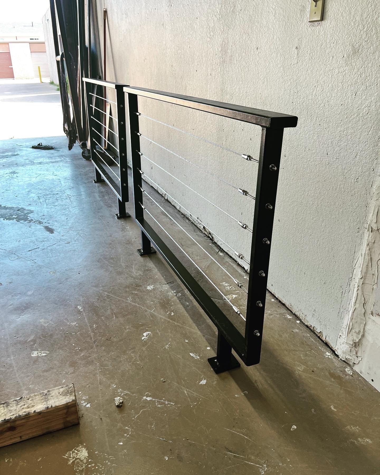 Custom black steel cable railing panels fabricated by Claudio Welding